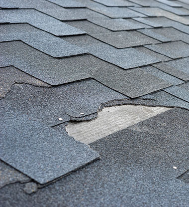 Broken asphalt shingles on a Salt Lake County roof before replacement