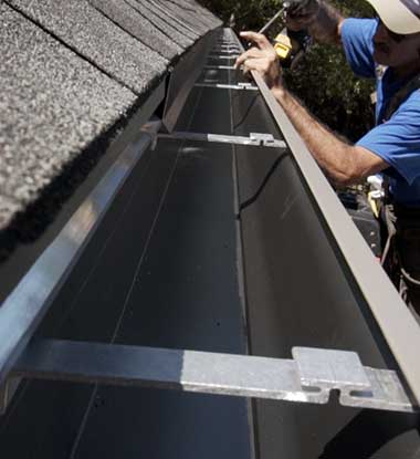 Salt Lake County crew installing aluminum gutters along roofline