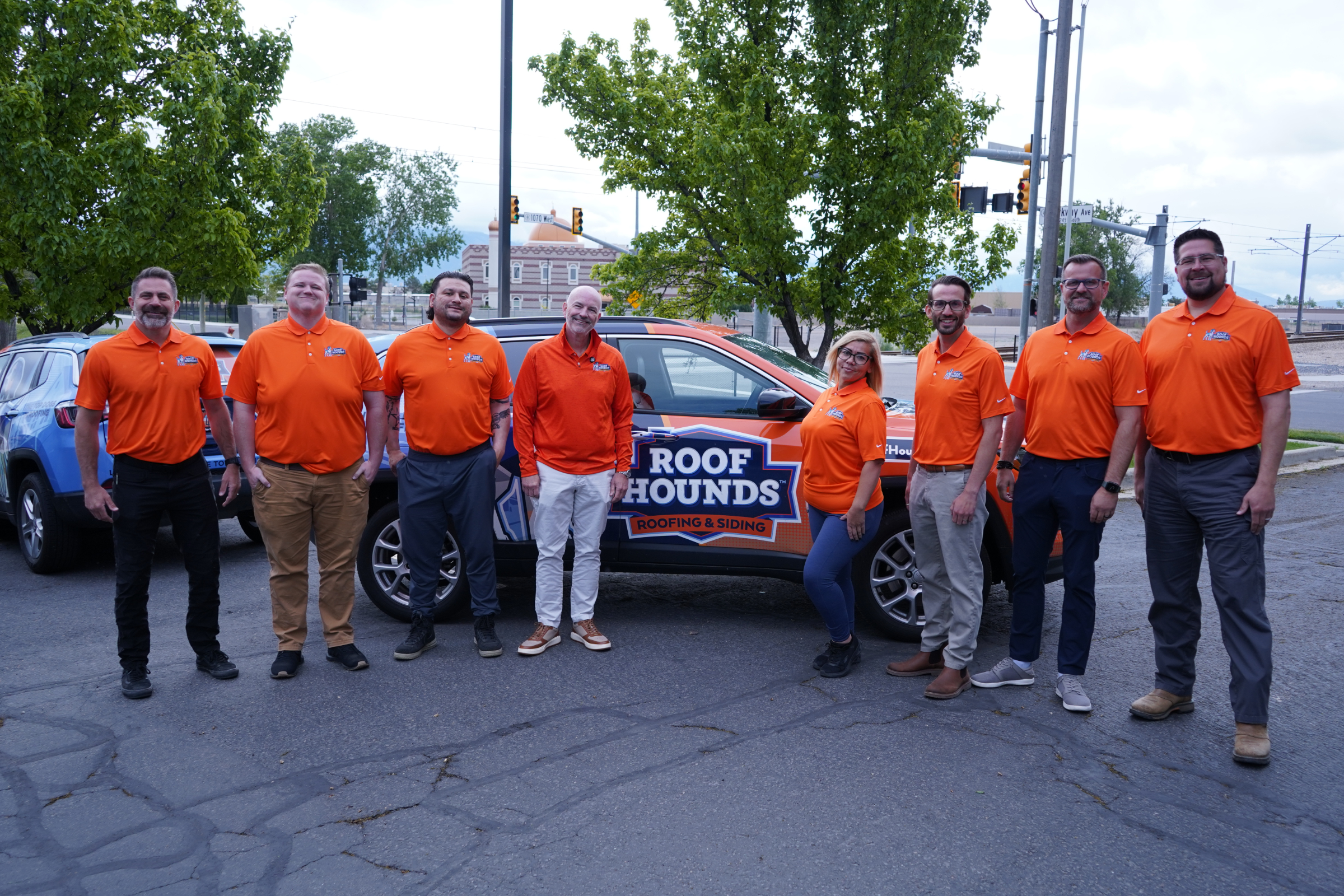 Roof Hounds team standing in front a branded vehicle in salt lake county