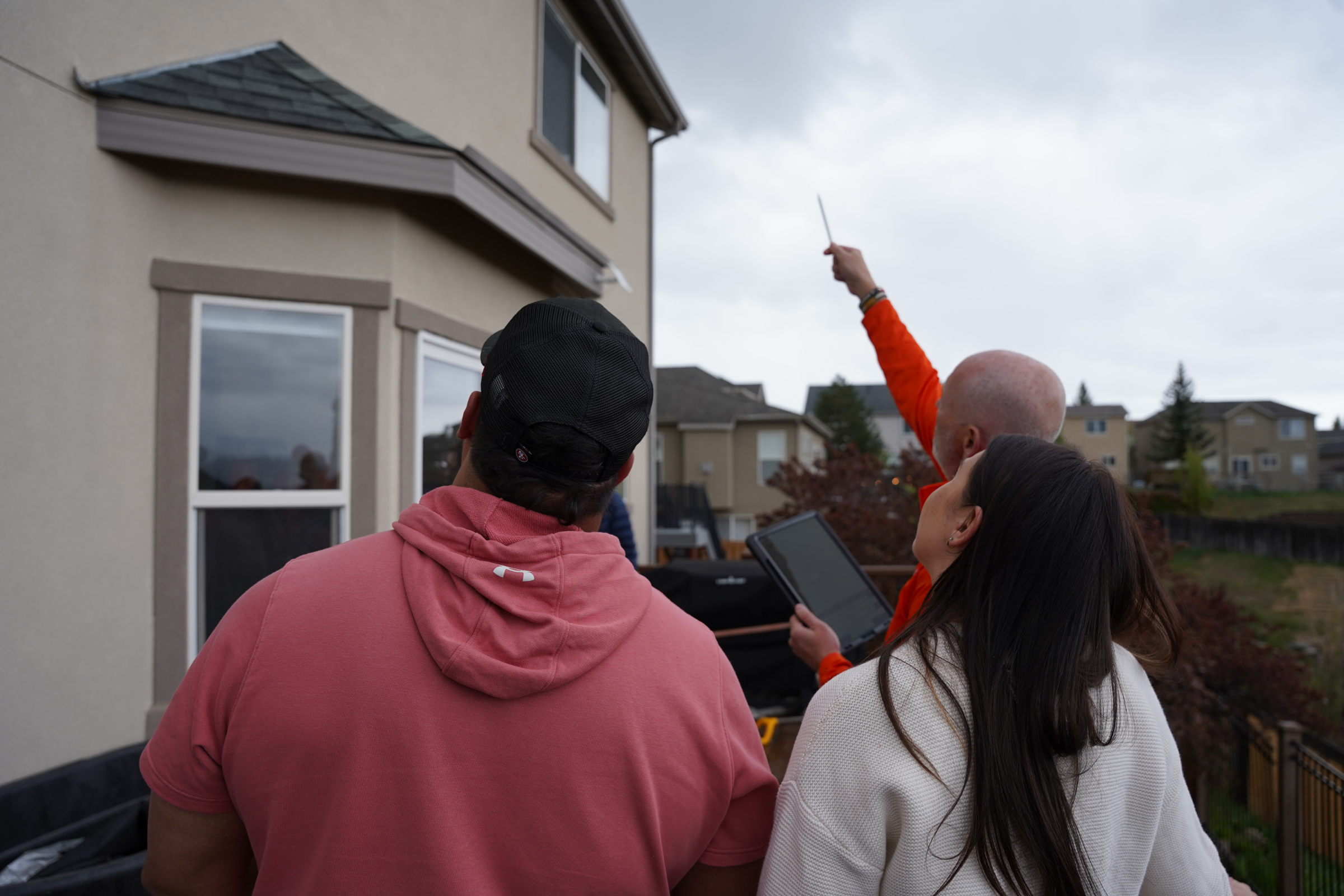 Roof Hounds employee discussing aluminum gutters with homeowners in salt lake county
