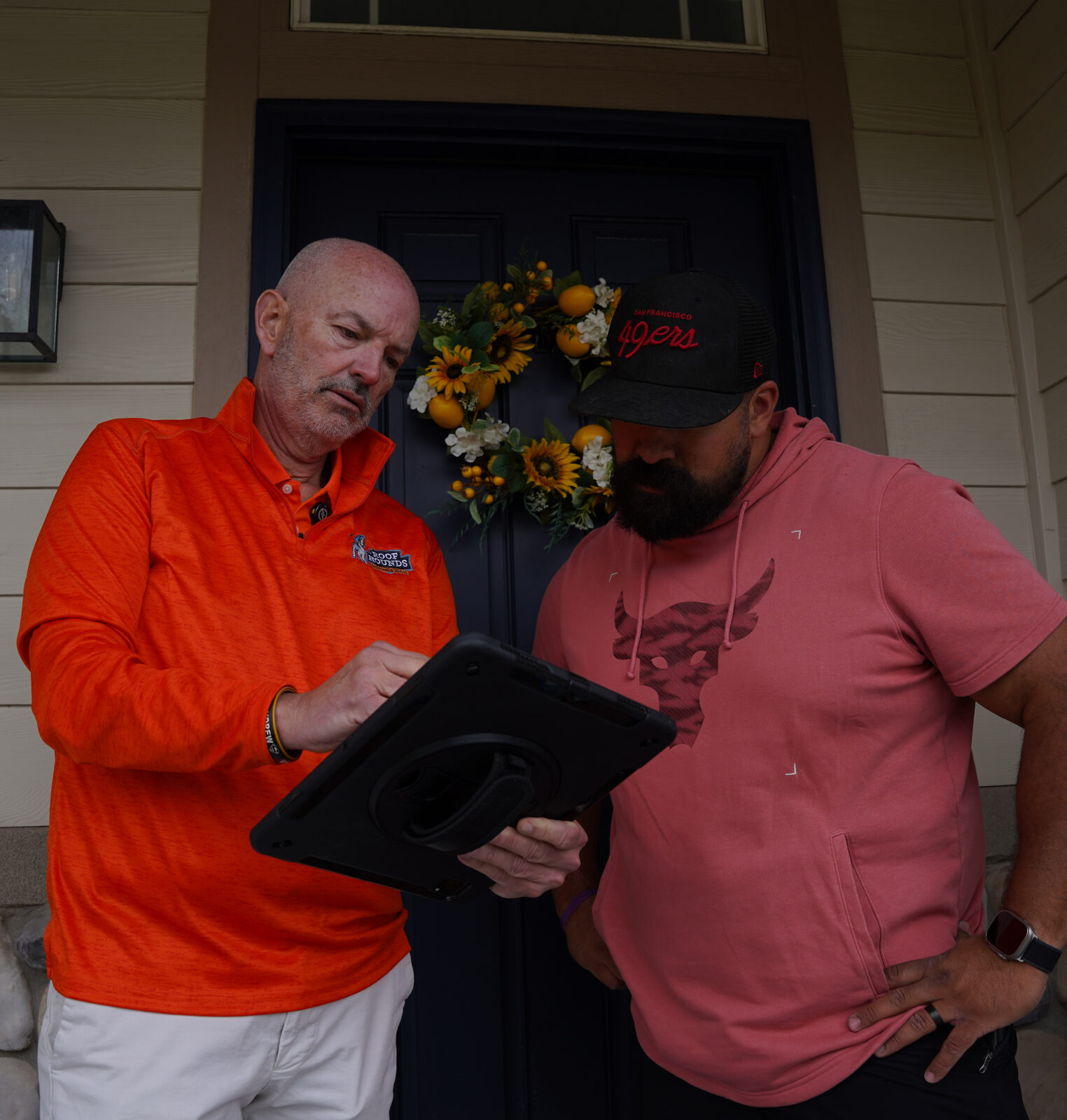 Roof Hounds employee reviewing door services with a homeowner in salt lake county