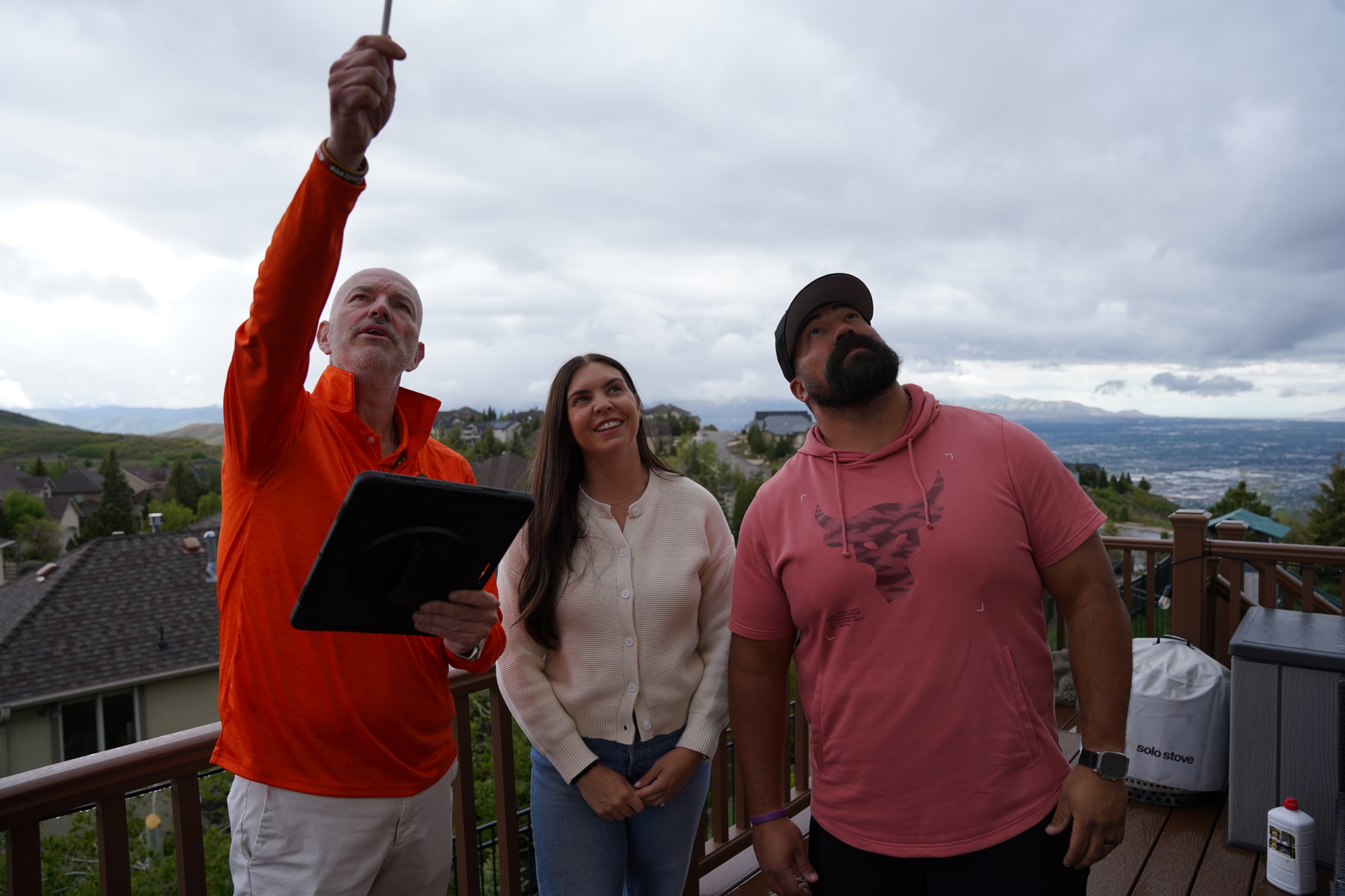professional examining existing gutters with homeowners in salt lake county to choose gutter services