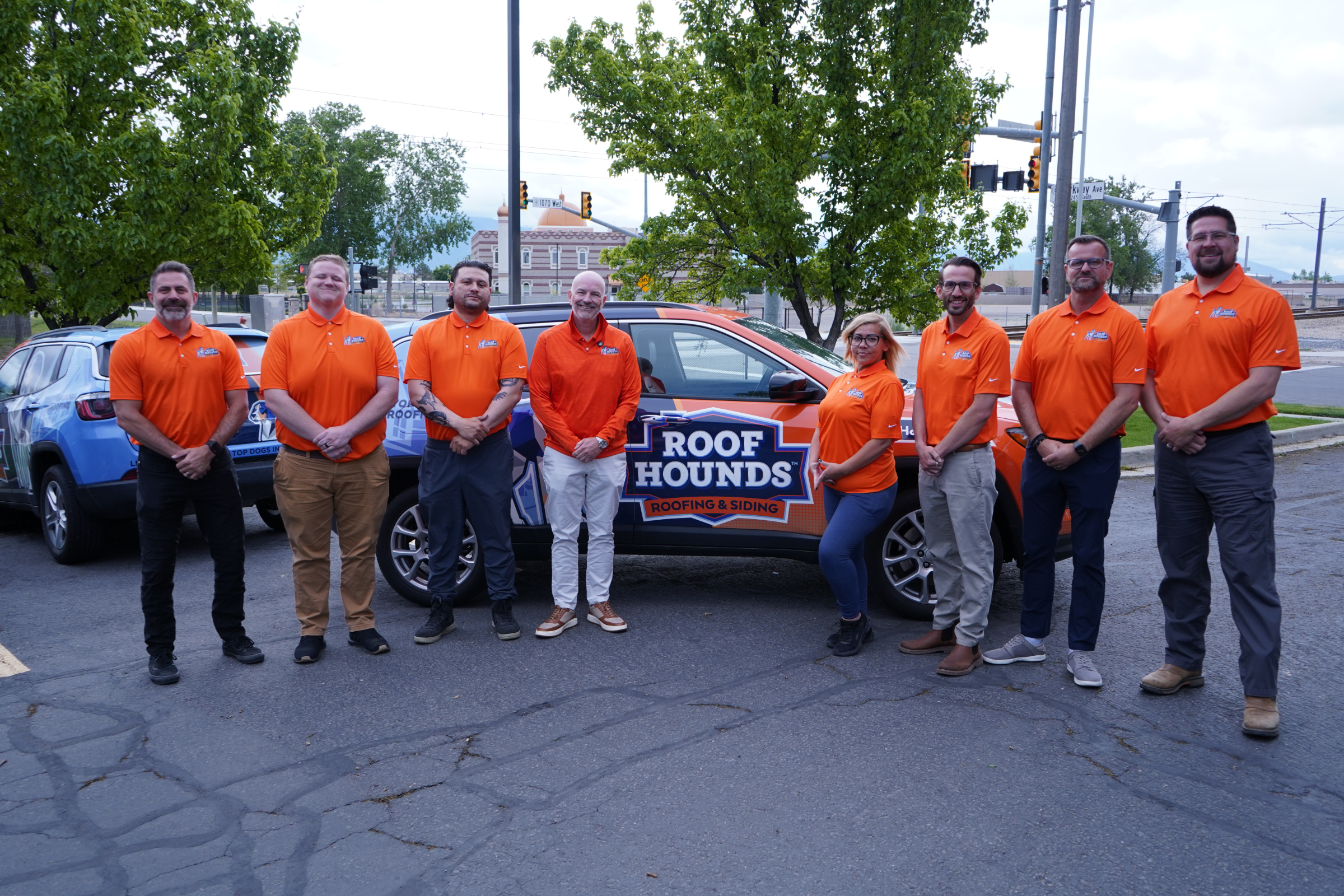 Roof Hounds team stands in front of a branded vehicle ready to offer residential roofing services in salt lake county