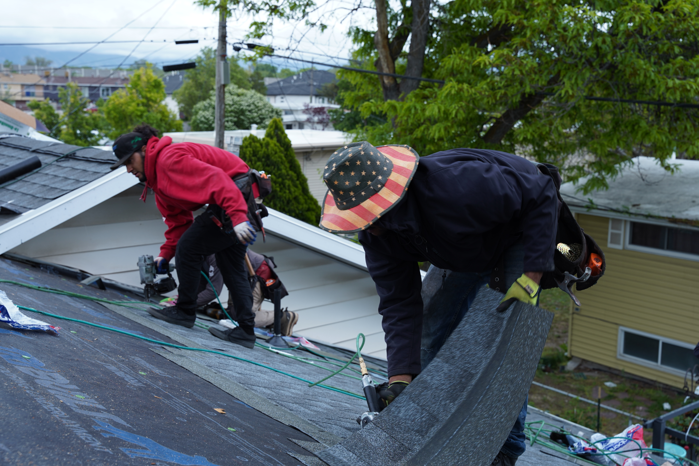 roofing contractors performing a roof replacement on a home in salt lake county