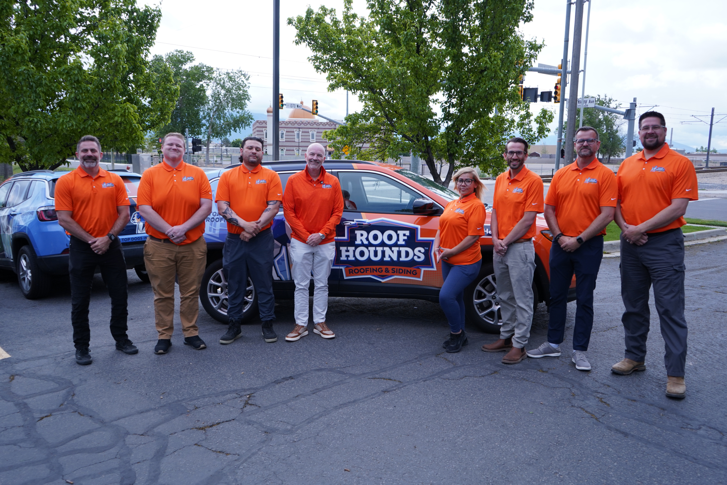 Salt Lake County 1a taggedRoof Hounds team standing in front of a branded vehicle for roofin services in