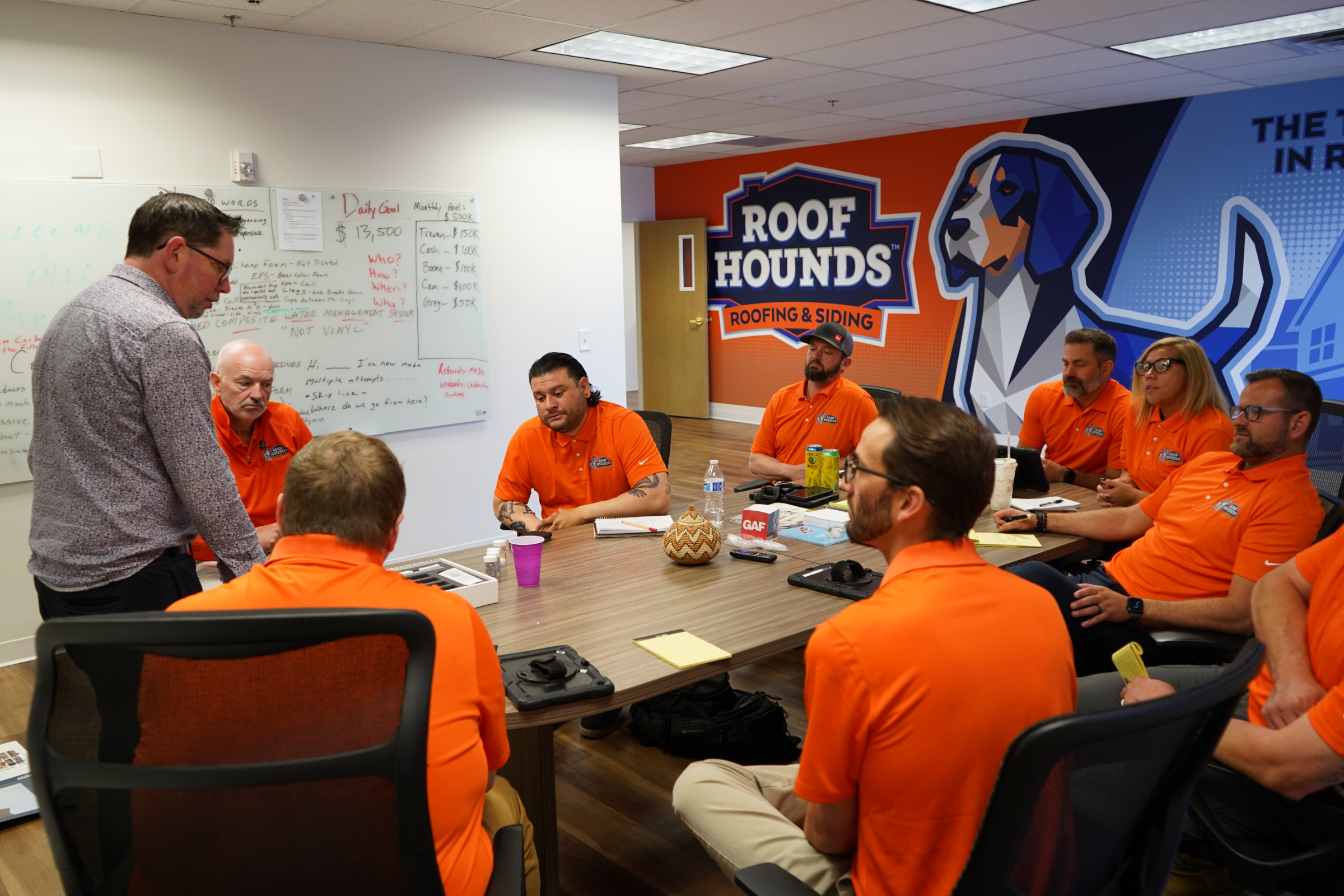 Roof Hounds team members discussing roofing services in their Salt Lake County office