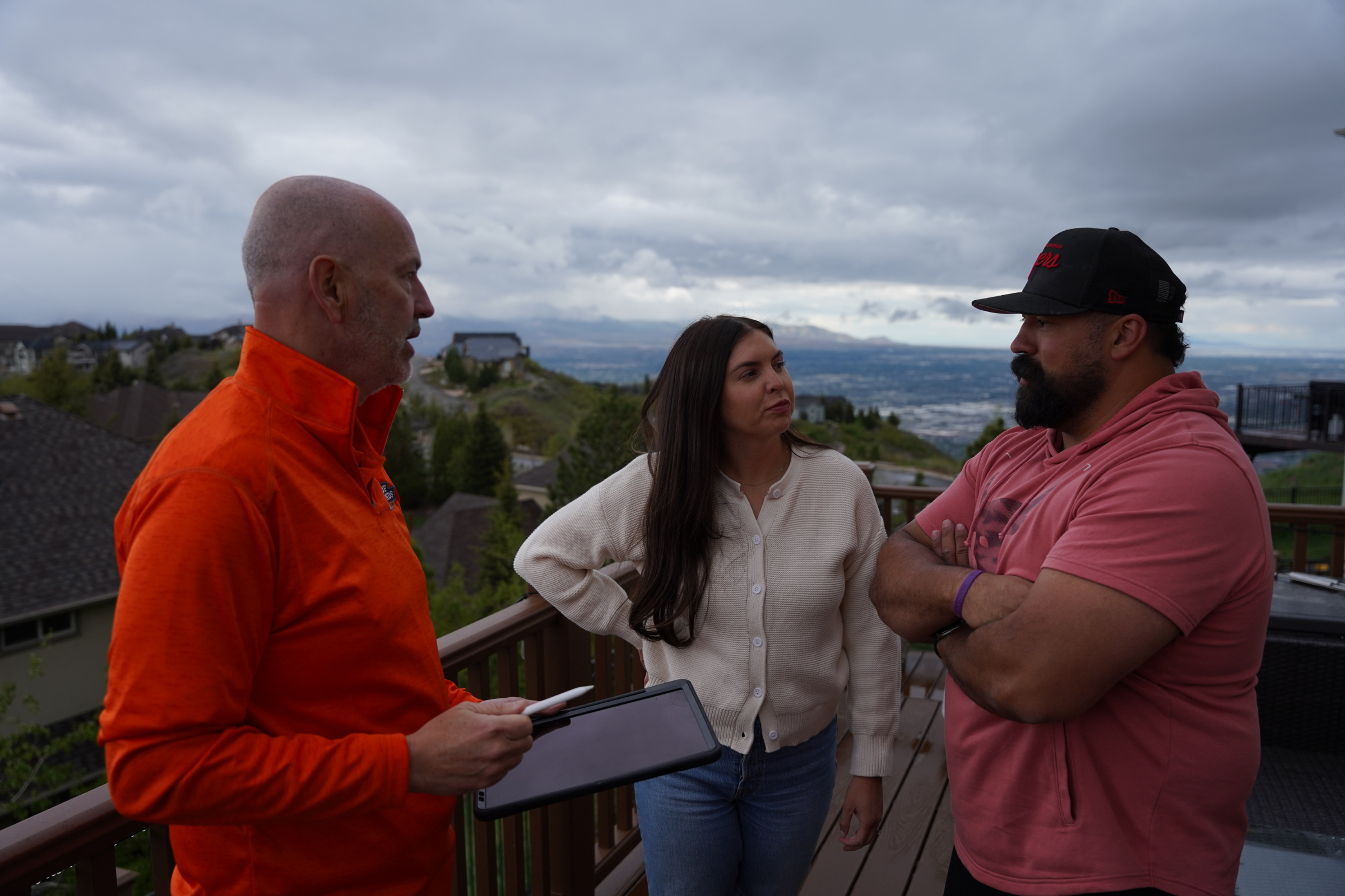 Roof Hounds employee explaining available roofing services to homeowners in salt lake county